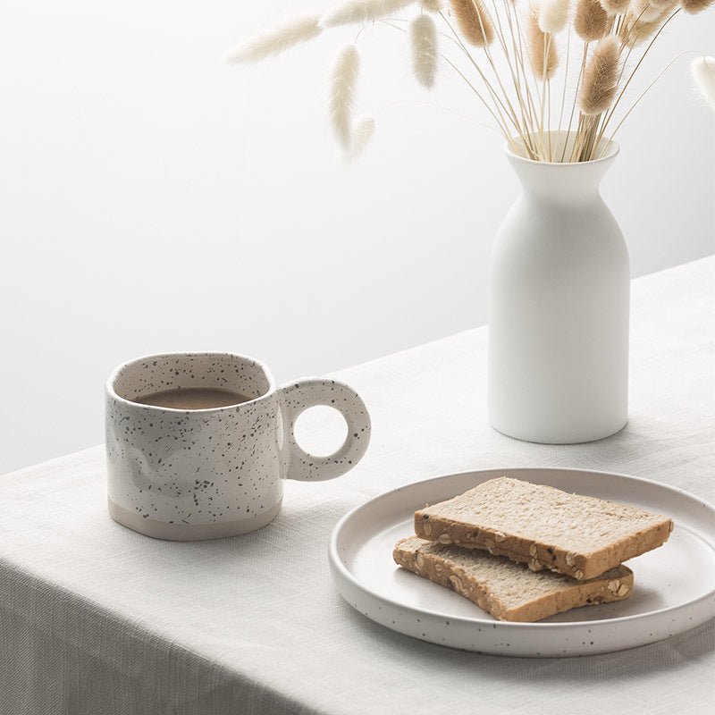 Lunar Clarity White porcelain tea cup with asymmetrical silhouette and cosmic ink-splash glaze by Recharge7.